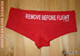 Shorty Remove before flight imprim� blanc sur fond rouge